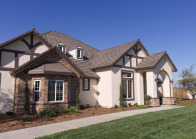 Front of cream colored home with dark brown and stone accents