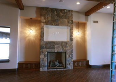 Stone fireplace with wood floors and built in seating