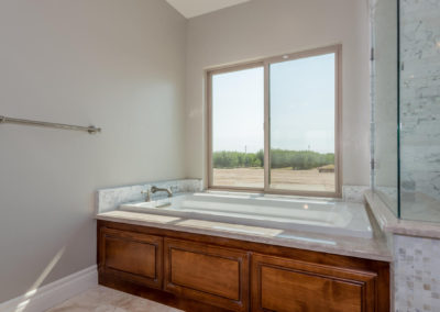 Soaking tub with large window over looking fields