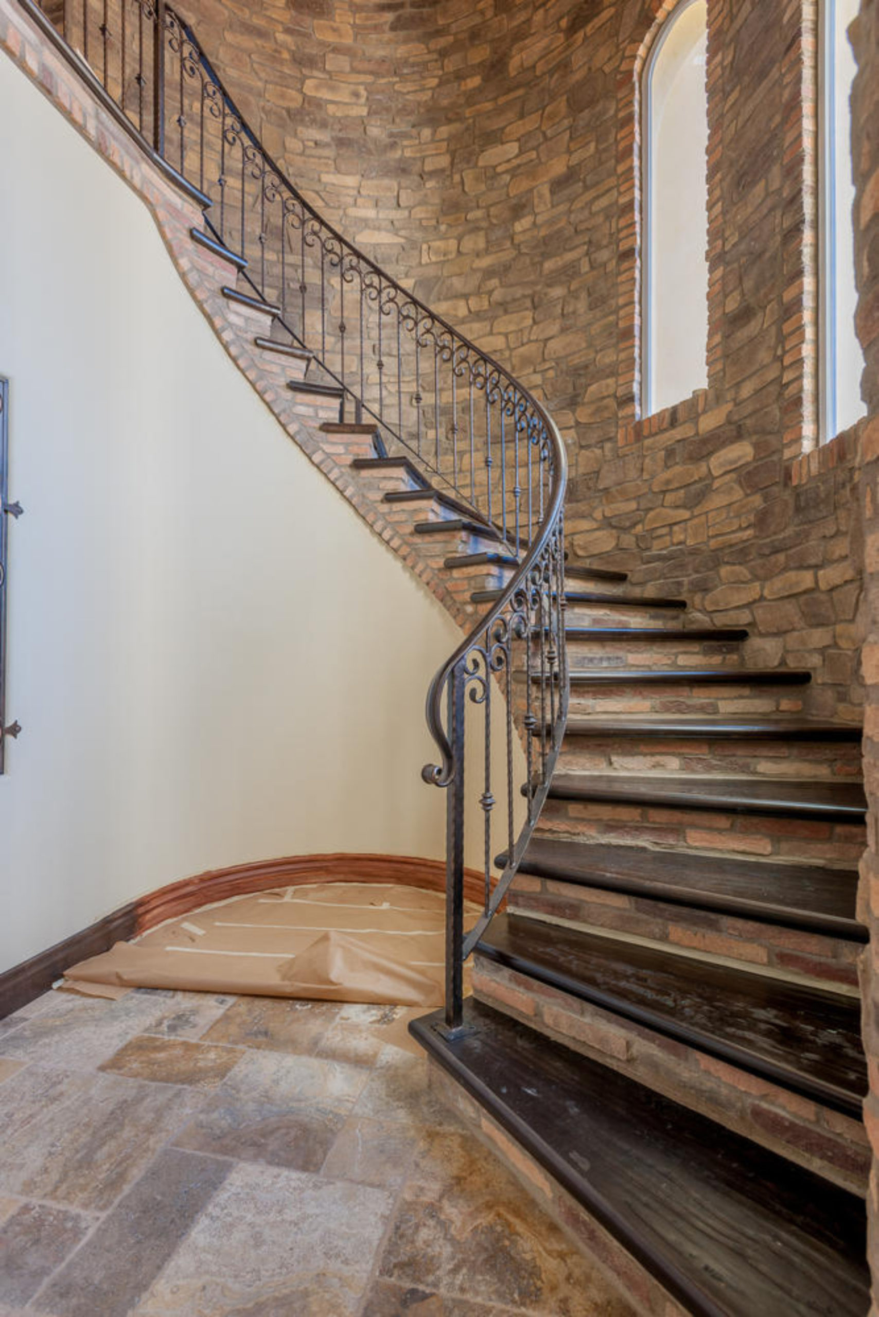 Curved stair case with stone wall