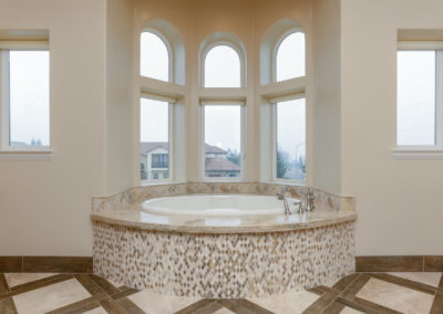 Large soaking tub with windows and inlay tile floor