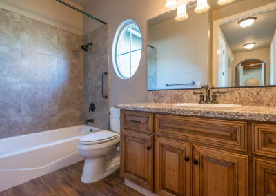 Bathroom showing sink and bathtub and toilet with circle window