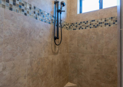 Stone shower with glass tile accents