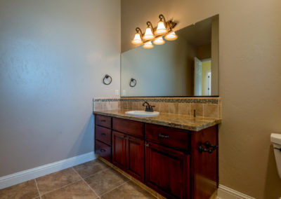 Single bathroom sink with light fixture and mirror