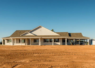 Front view of newly constructed home on dirt lot