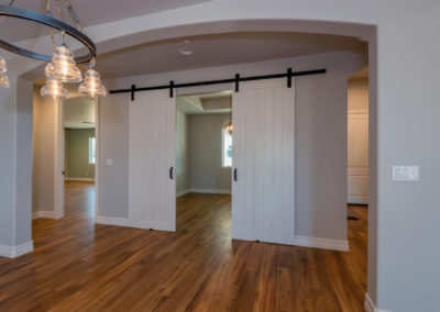 Newly constructed home with hanging barn doors and light fixture