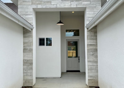 Doorway with white brick and hanging light fixture