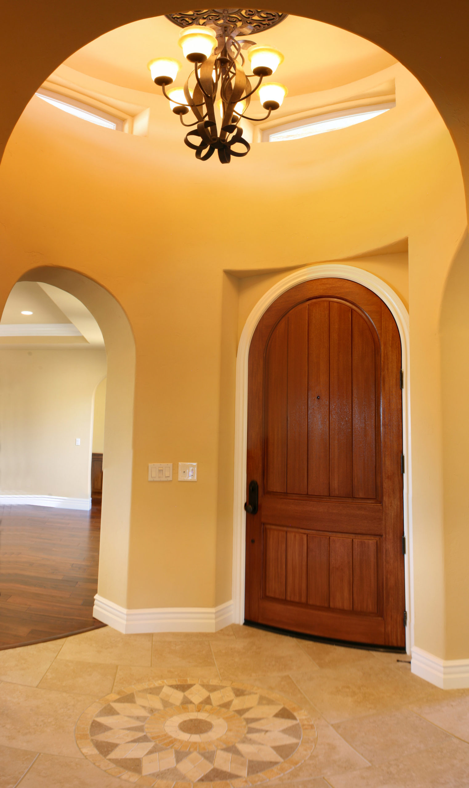 Entry area of home showing arched doorways and inlay flooring