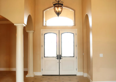 Double entry door with high ceiling and chandelier