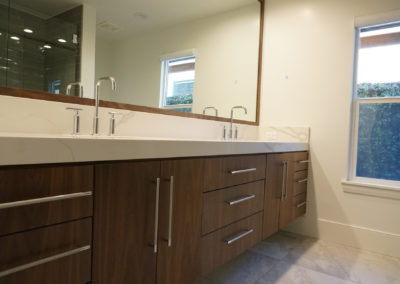 Double bathroom sink with large mirror and sleek cabinets