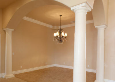 Arched dining area with pillars and chandelier