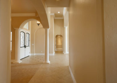 Cream walls of hallway leading to main entrance with pillars