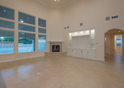 Open area of newly constructed home with fireplace and built in shelving