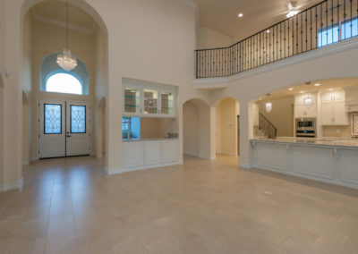 Inside of newly constructed home, looking at front entry and kitchen