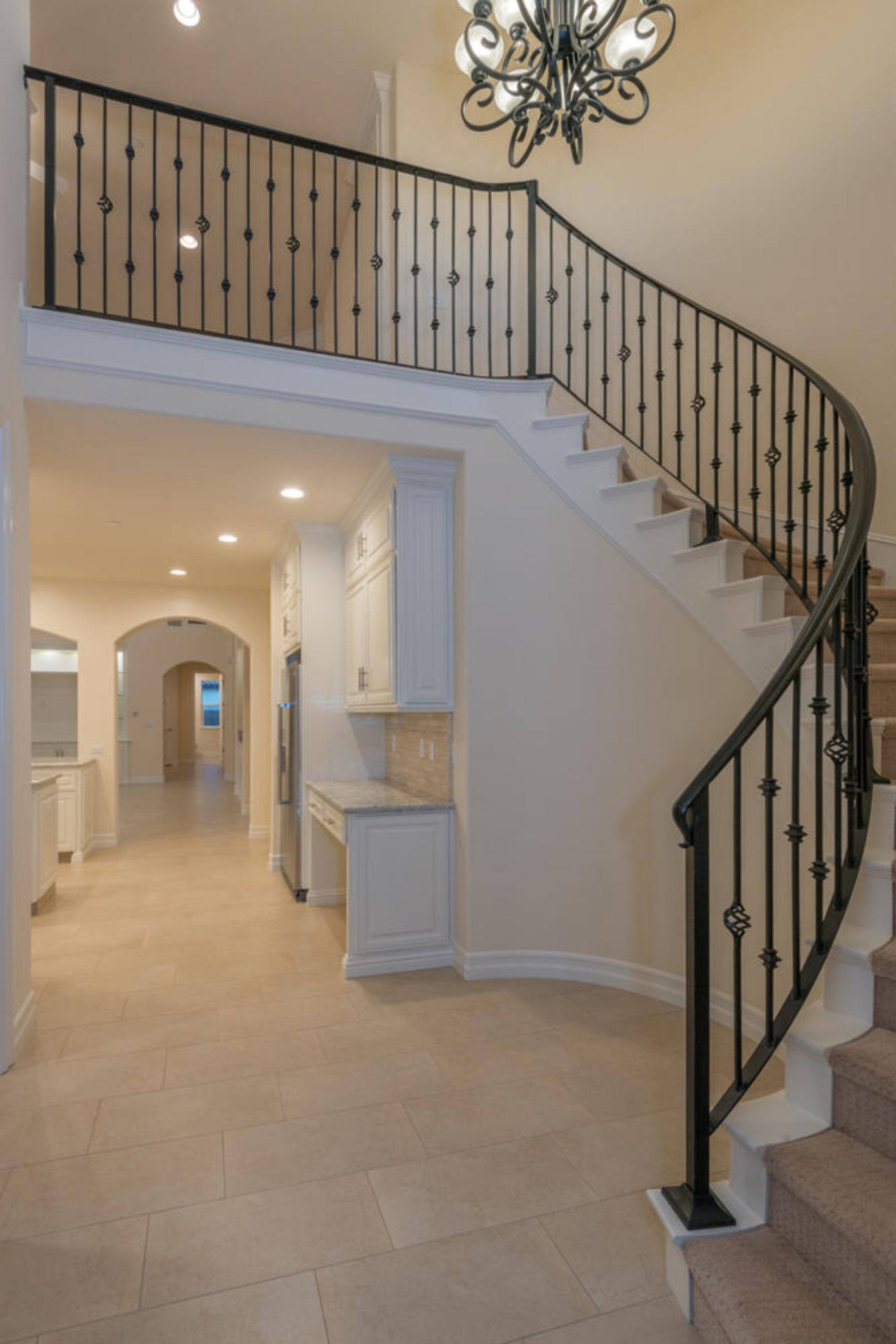Curved staircase with iron banister with cream walls