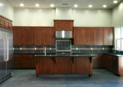 Brown and green kitchen with island and custom cabinets