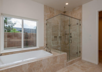 Bath tub with glass shower and large window looking outside