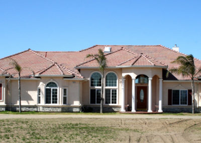 Newly constructed home with columns and blue sky