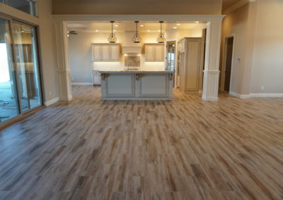 Family area facing kitchen with wood floors