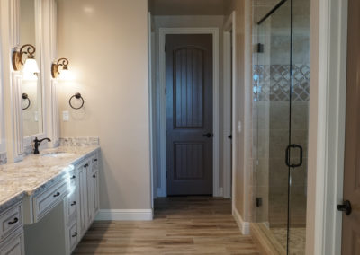 Bathroom with wooden floor leading to doorway