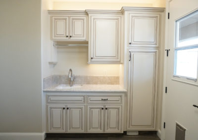 Custom white cabinets and sink with door