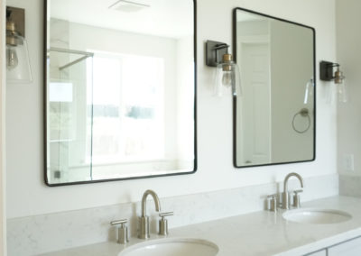 White bathroom with two sinks and two mirrors