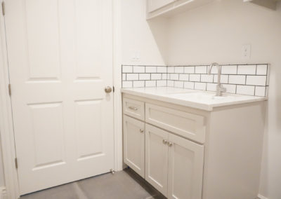 Laundry room sink and cabinets in white