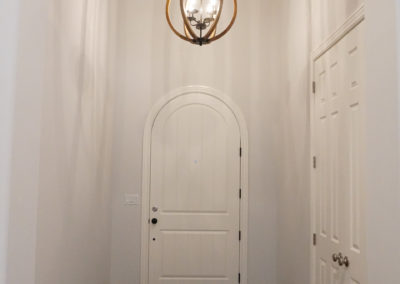 Hallway leading to arched white door