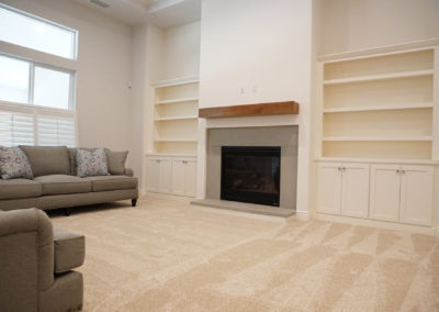 White living room with fireplace and built in shelves