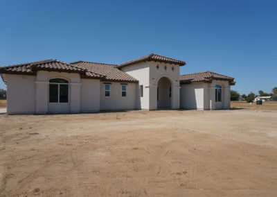 Side view of new home on dirt lot