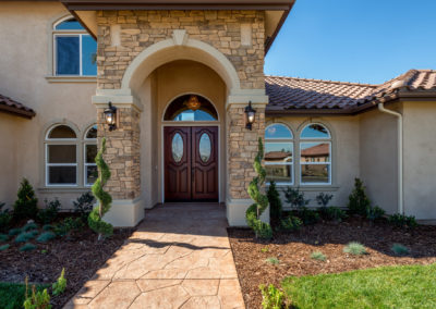 Tan home with wooden double entry doors