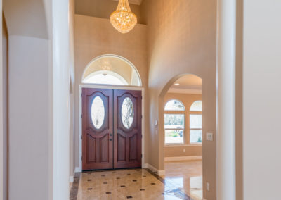 Tall entryway with marble floors and chandelier