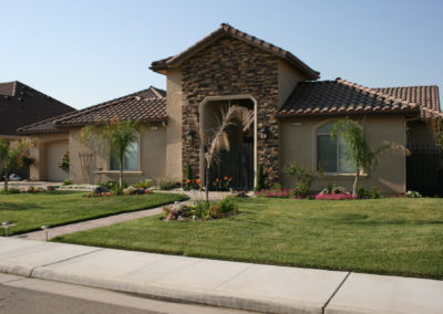 Brown home with stone accents and grass