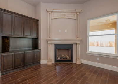 Room with tan walls, wooden floor and fireplace