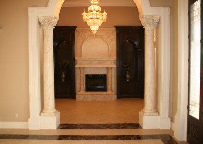 Marble fireplace with columns and chandelier