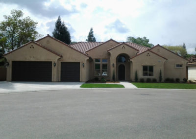 Tan home with dark accents and clay shingle roof