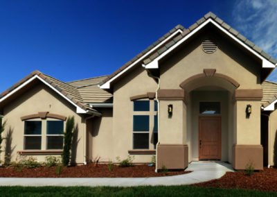 Tan home with windows and front walkway leading to door