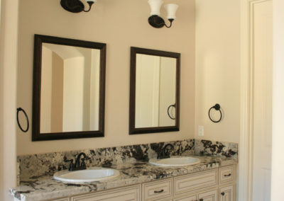 Bathroom with two sinks and two mirrors trimmed in black