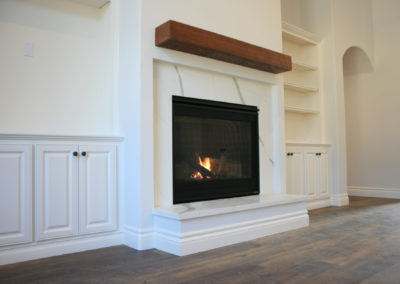 White fireplace with wooden floors