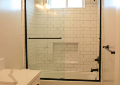 White bathroom with subway tile and glass shower doors