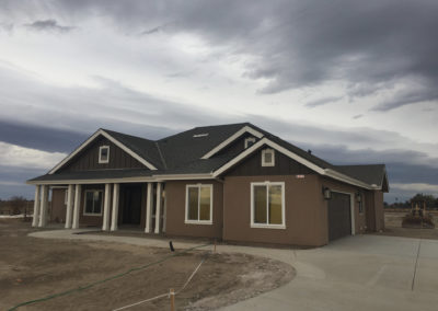 Dark brown newly constructed home on dirt lot