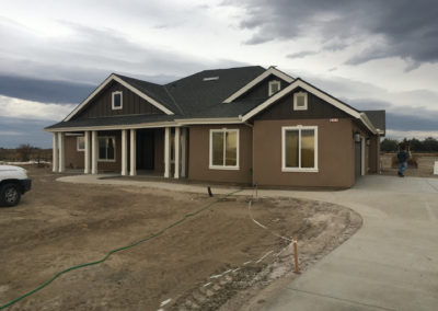 Dark brown newly constructed home on dirt lot