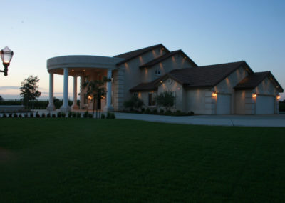 Large home with columns at dusk with lamp post