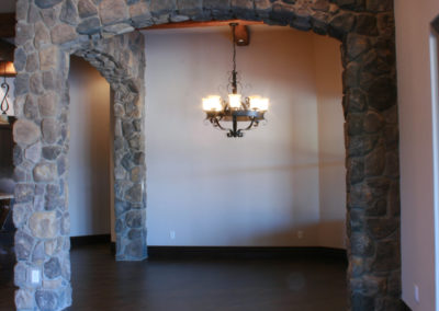 Room with dark floors and stone entrance