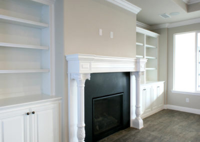 Large fireplace and built in white cabinets