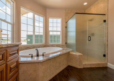 Large soaker tub with glass shower stall and windows