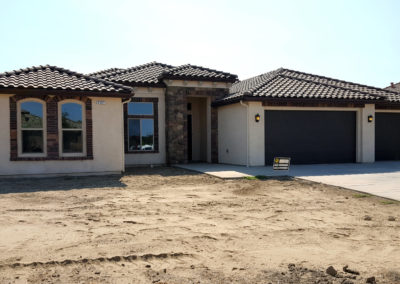 Front of newly constructed cream home with dark accents