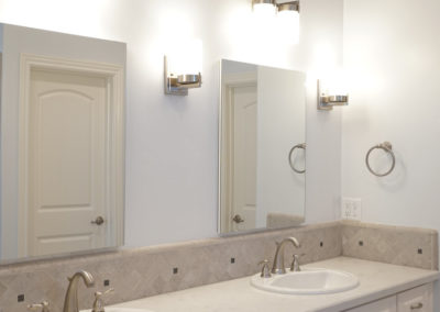 White bathroom with double sinks and mirrors