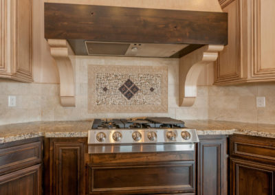 Brown kitchen with custom stove hood vent