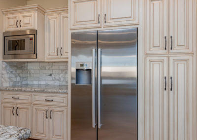 cream and light kitchen with stainless refrigerator stone back splash